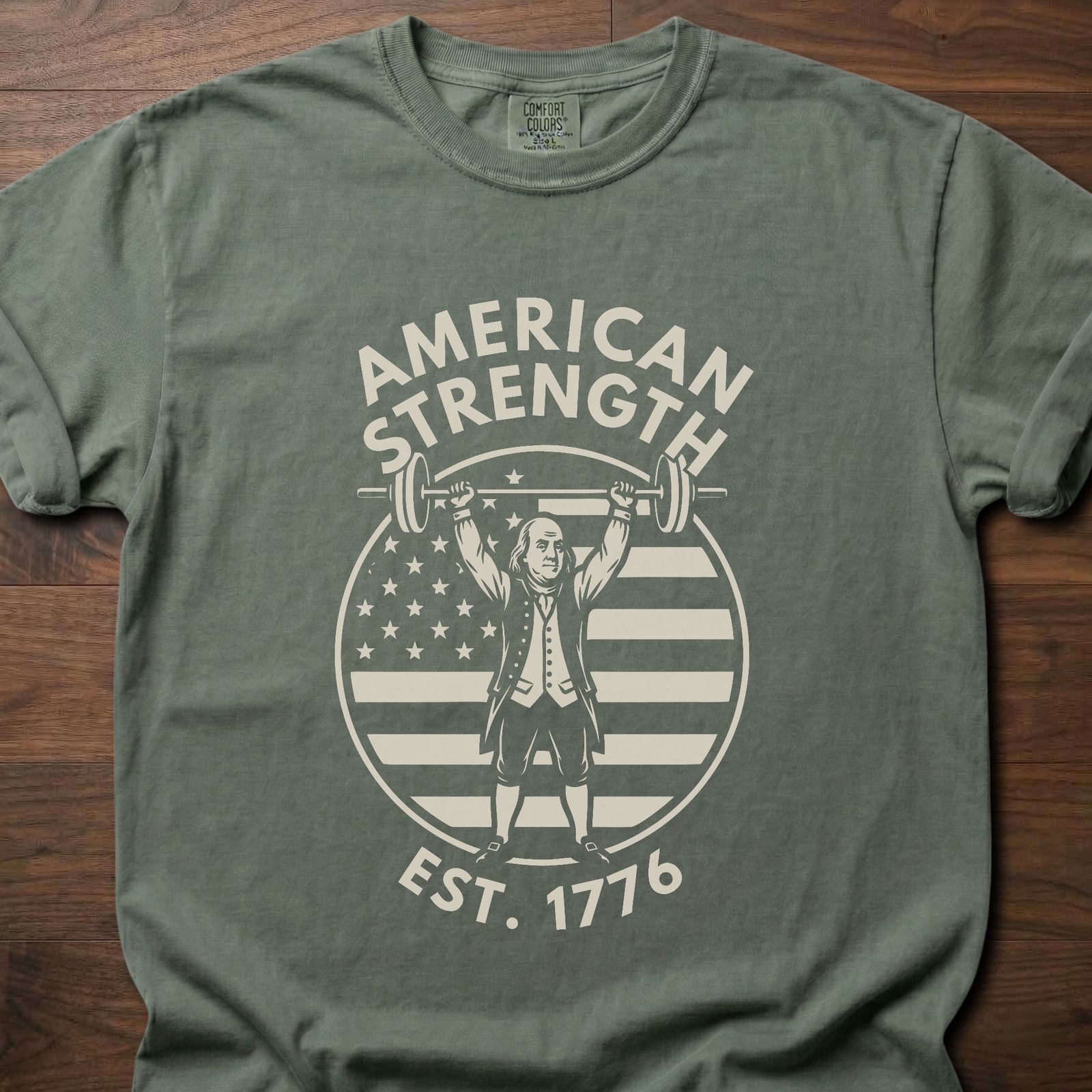 American Strength strength training t-shirt featuring Benjamin Franklin lifting barbell with flag design – Moss