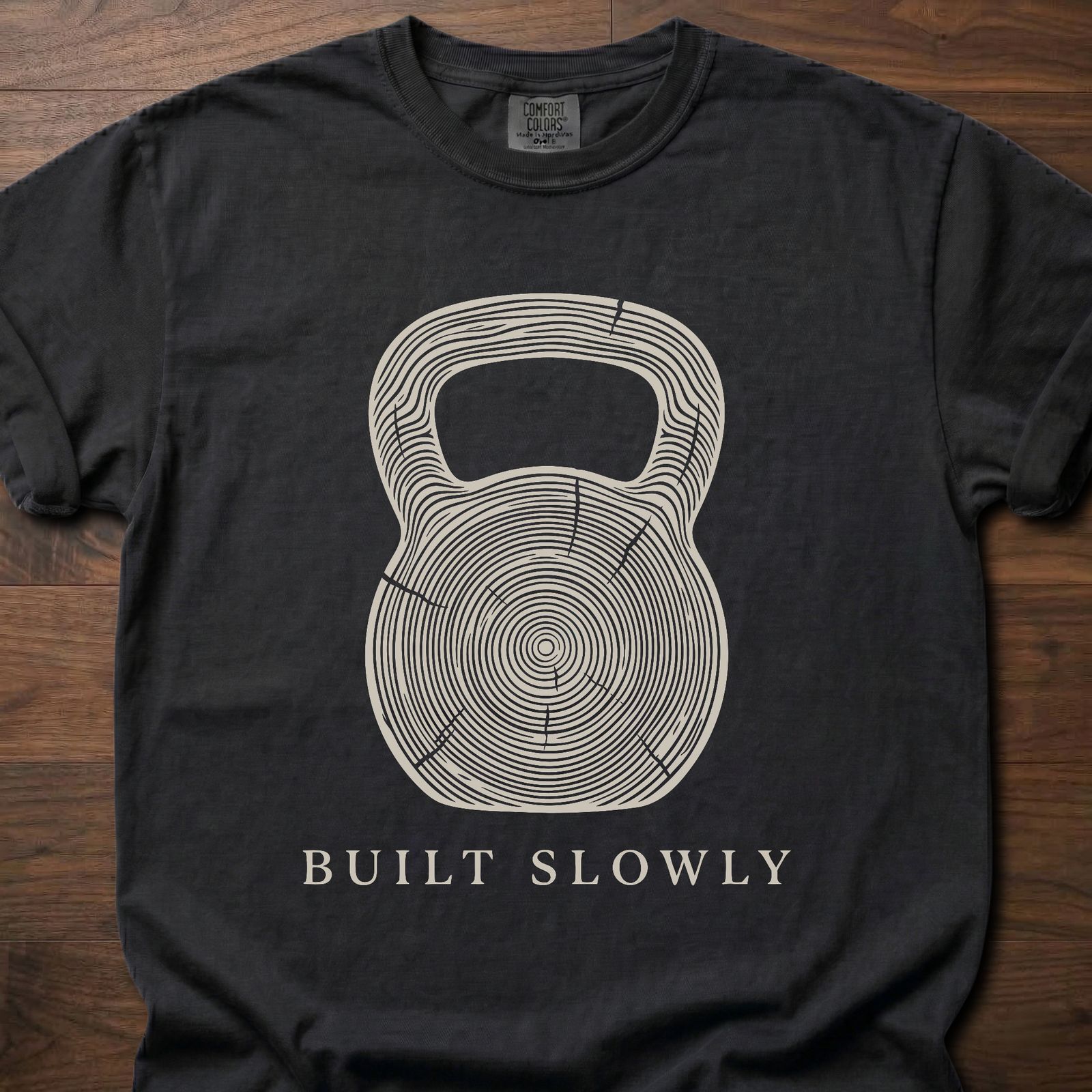 Built Slowly fitness lifestyle t shirt featuring kettlebell with tree ring growth pattern design – Black