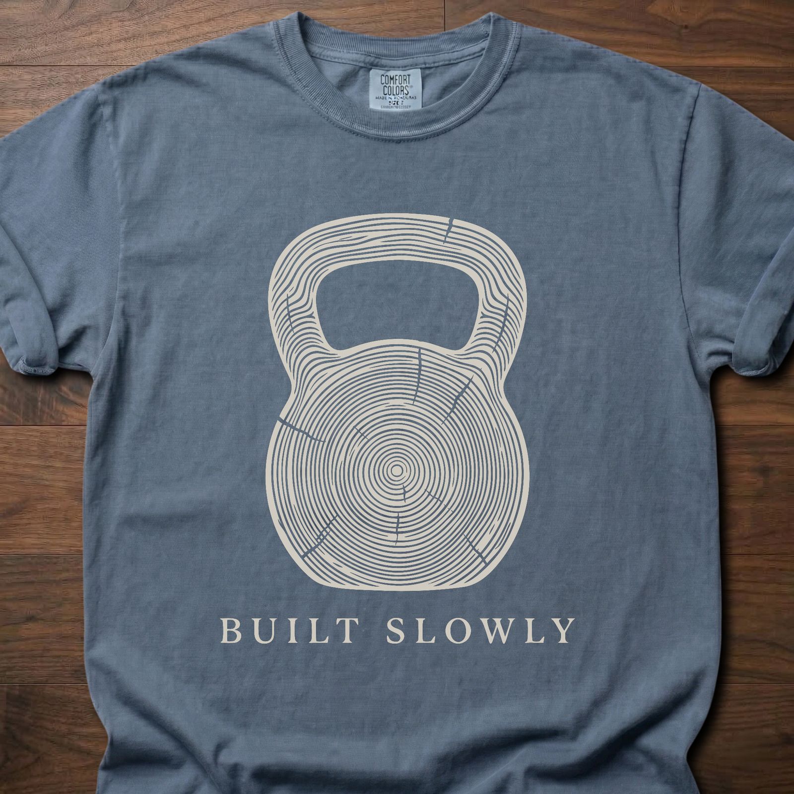 Built Slowly fitness lifestyle t shirt featuring kettlebell with tree ring growth pattern design – Blue Jean