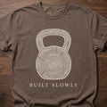 Built Slowly fitness lifestyle t shirt featuring kettlebell with tree ring growth pattern design – Espresso