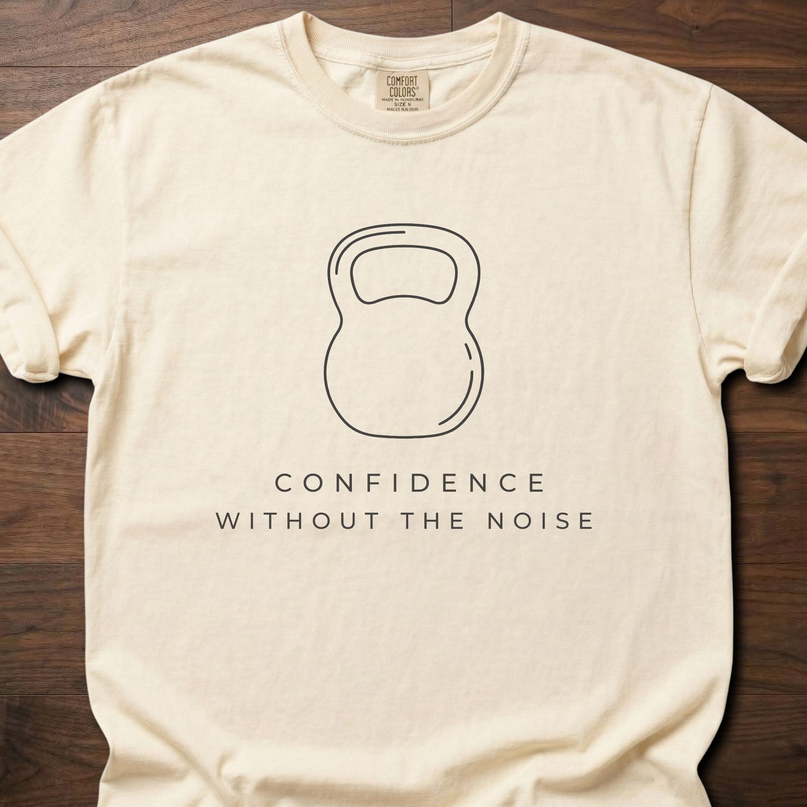 Confidence Without The Noise gym lifestyle shirt featuring minimalist kettlebell outline design – Ivory