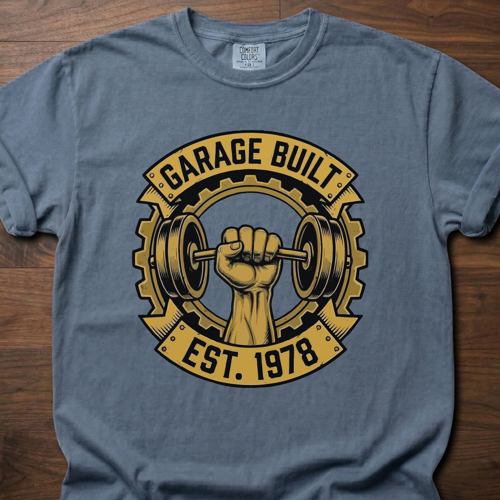 Garage Built gym lifestyle shirt featuring muscular fist gripping barbell with gear emblem EST. 1978 – Blue Jean