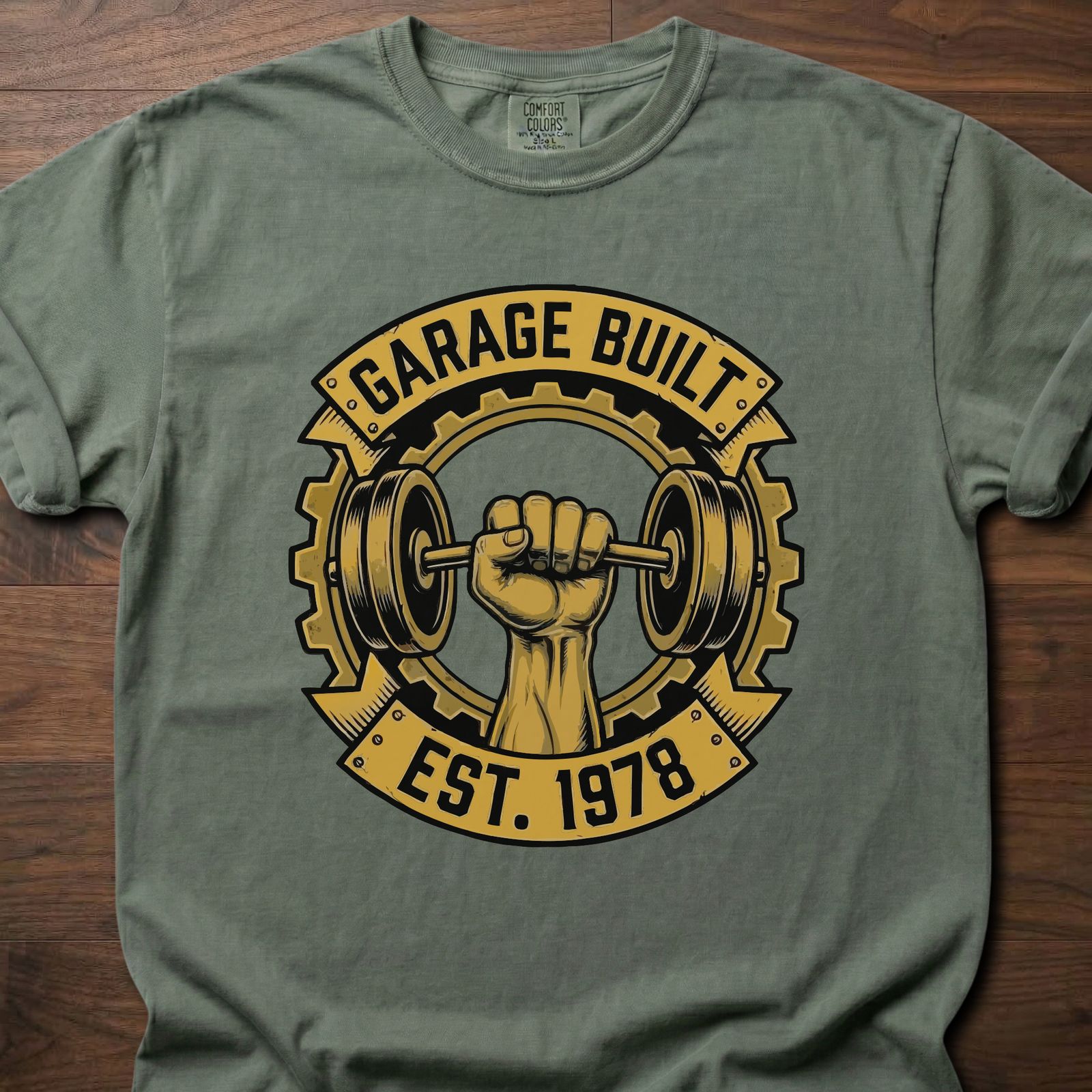 Garage Built gym lifestyle shirt featuring muscular fist gripping barbell with gear emblem EST. 1978 – Moss