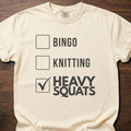 Heavy Squats strength training t-shirt with checkbox list showing heavy squats selected – Ivory