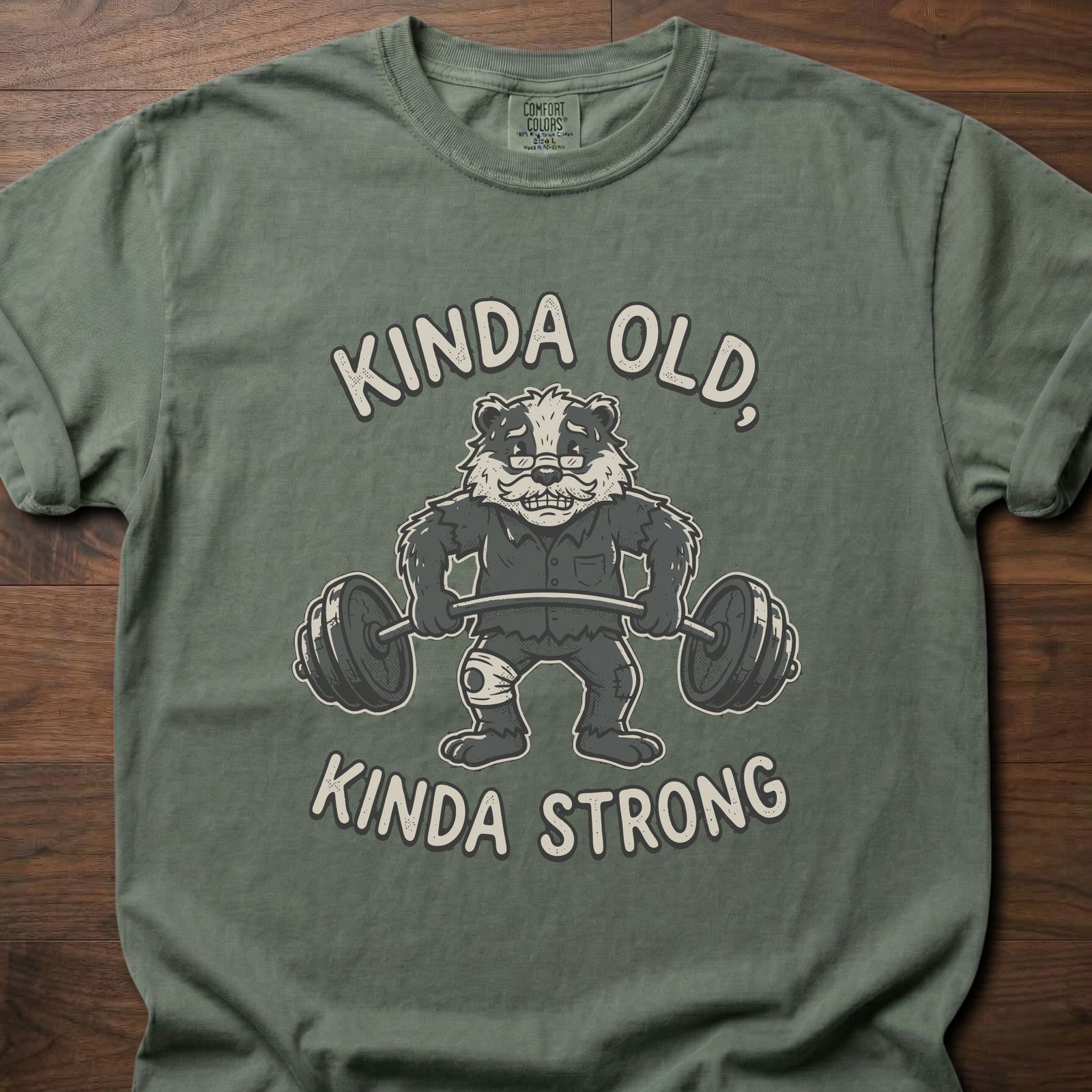 Kinda Old Kinda Strong strength training t shirt featuring weightlifting badger with barbell – Moss
