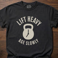 Lift Heavy Age Slowly strength training t-shirt with kettlebell and clock hands graphic – Black