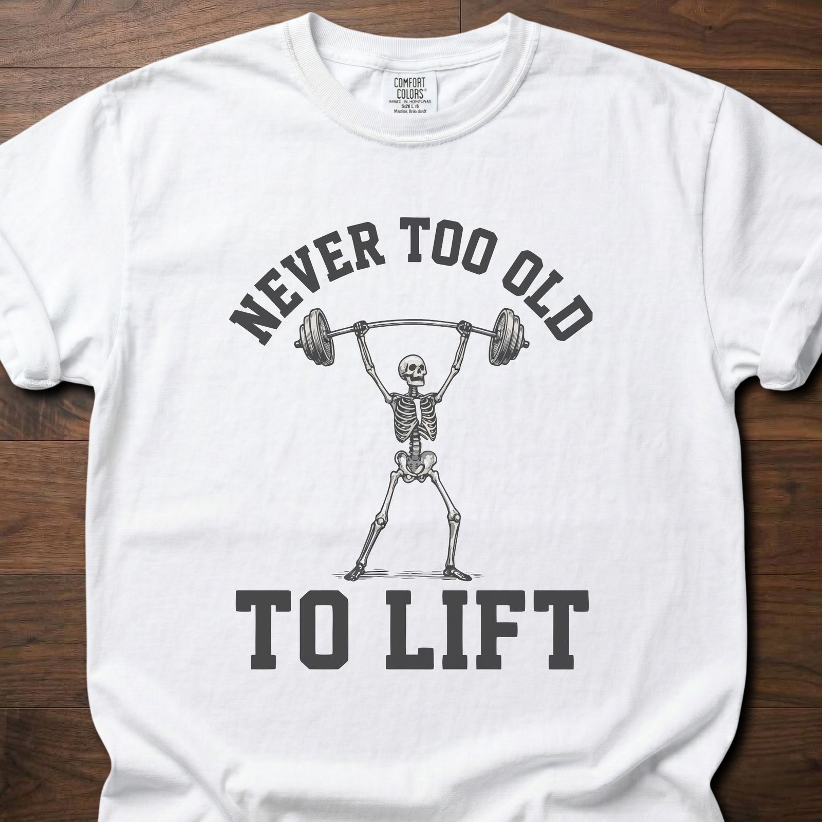 Never Too Old gym lifestyle shirt featuring skeleton lifting barbell overhead – White