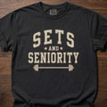 Sets And Seniority strength training t-shirt with collegiate lettering, stars, and barbell graphic – Black