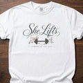 She Lifts strength training t-shirt with barbell and floral design – White
