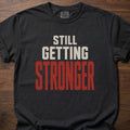 Still Getting Stronger strength training t-shirt with bold stacked block lettering – Black