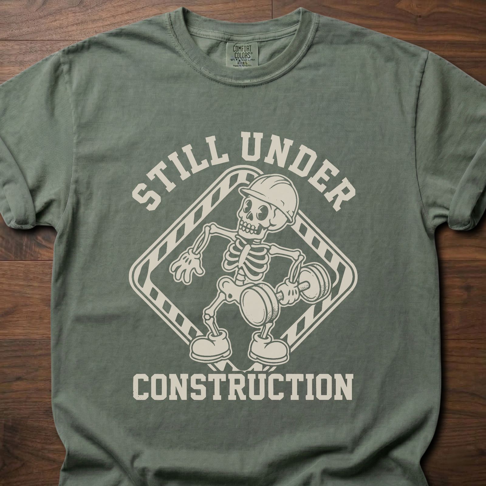 Still Under Construction strength training t shirt featuring skeleton with hard hat and caution tape design – Moss