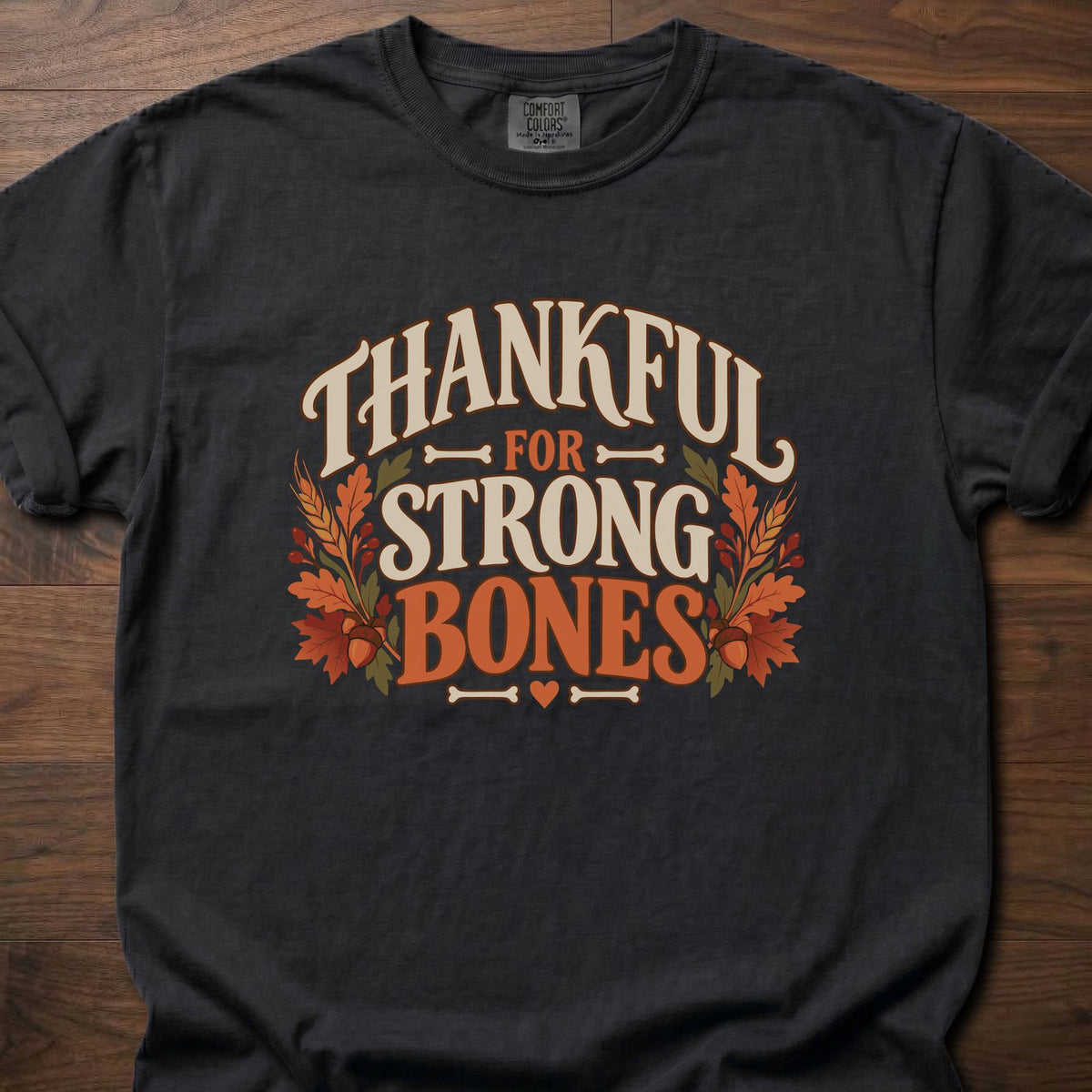 Thankful For Strong Bones strength training t-shirt with vintage collegiate typography and botanical – Black