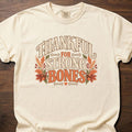 Thankful For Strong Bones strength training t-shirt with vintage collegiate typography and botanical – Ivory