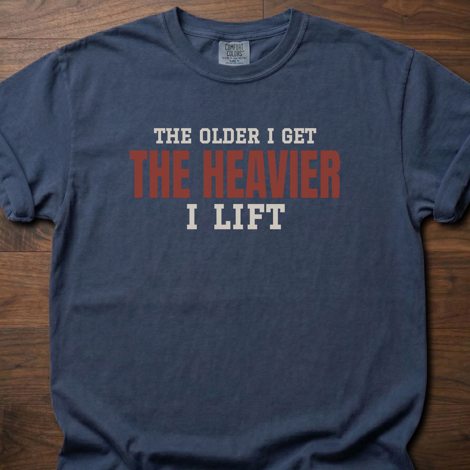 The Heavier I Lift fitness lifestyle t-shirt with bold stacked block-letter text design – Navy