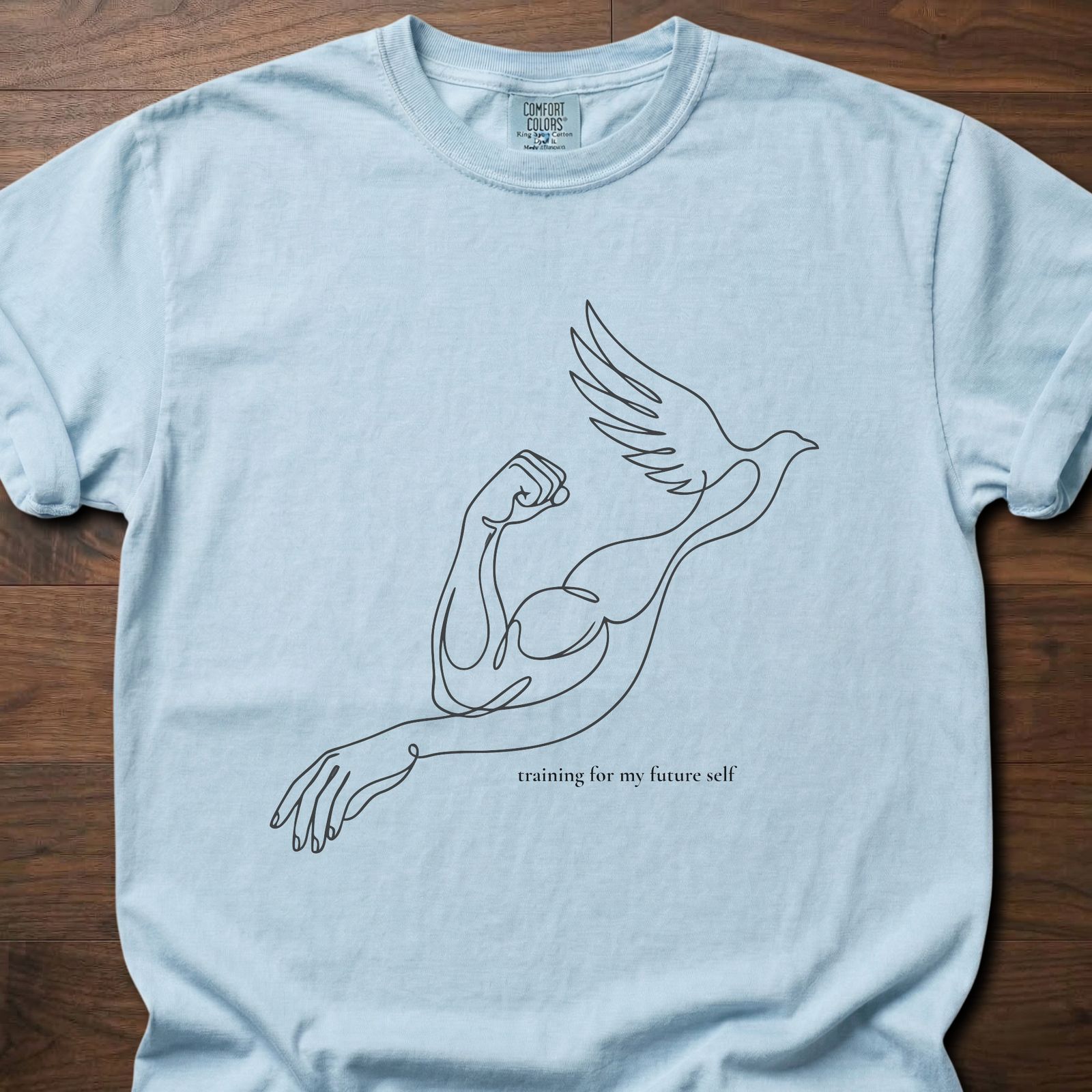 Training for My Future Self strength training t-shirt with figure lifting bird in flight design – Chambray