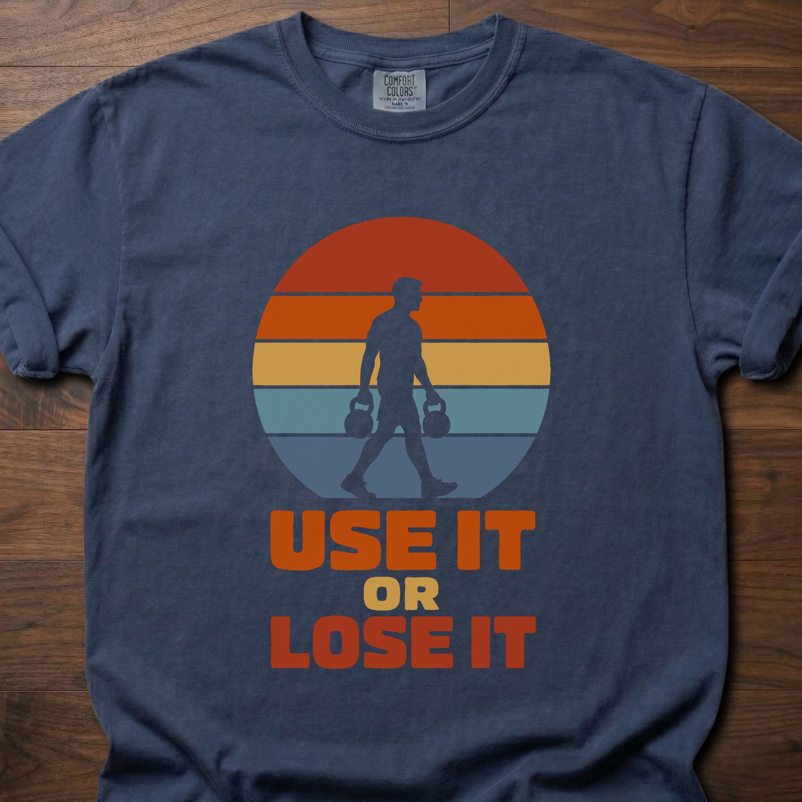 Use It Or Lose It strength training t-shirt with kettlebell walk and retro sunset graphic – Navy